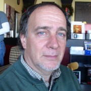 Man with receding dark hair and a gray goatee